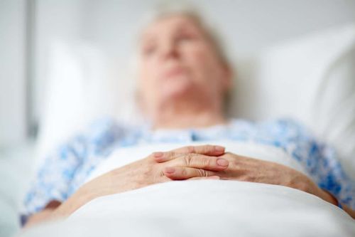 Close-up of hands of senior woman lying in hospital ward - Develop a Bed Sore in Nursing Home concept