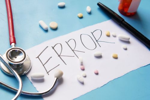 medical error text on a paper with pills and stethoscope on table