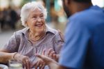 elderly woman talking to a nursing home staff member - is mom safe in the nursing home concept?